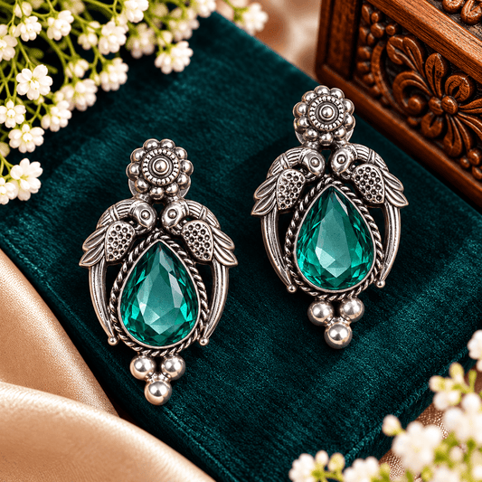 Emerald green teardrop oxidized statement earrings with decorative bird motifs by The Mirage Fashion