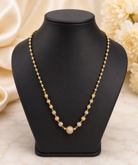 17-inch gold-plated Mug Mala necklace with gold and silver-tone beads and a CZ-studded center bead on a black jewelry bust.  The Mirage Fashion