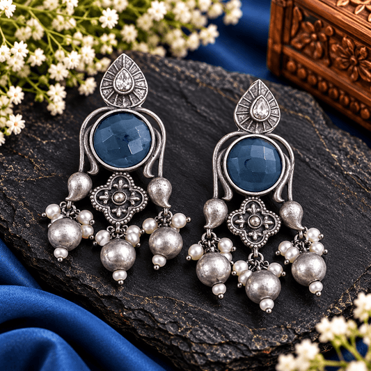 Antique silver-tone oxidized statement earrings with round midnight-blue stones, floral detailing and pearl-style bead danglers