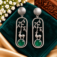 Antique silver-tone deer motif earrings with leafy branches and emerald-green stones