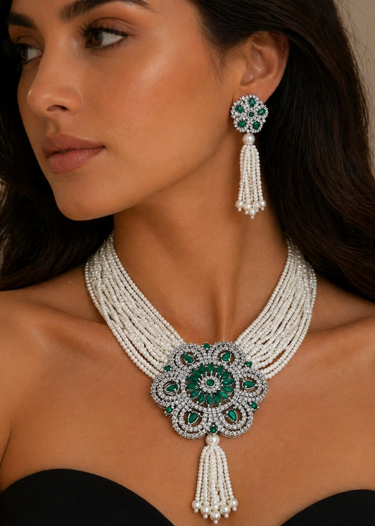 Woman wearing a luxurious necklace and earrings with green gemstones on a neutral background