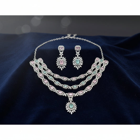 Jewelry set with necklace and earrings featuring pink and green gemstones on a white background