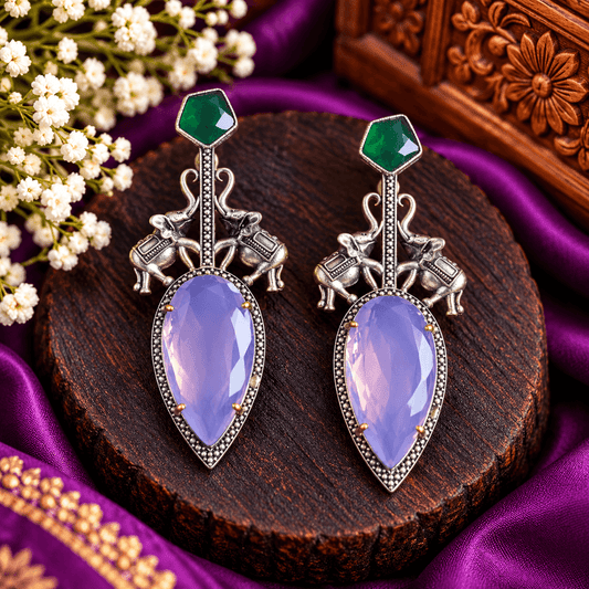 Oxidized silver-tone statement earrings with elephant motifs, lavender-purple faceted stones and emerald-green accents