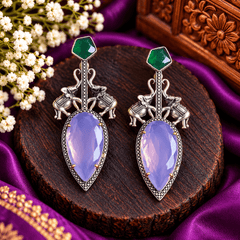 Oxidized silver-tone statement earrings with elephant motifs, lavender-purple faceted stones and emerald-green accents