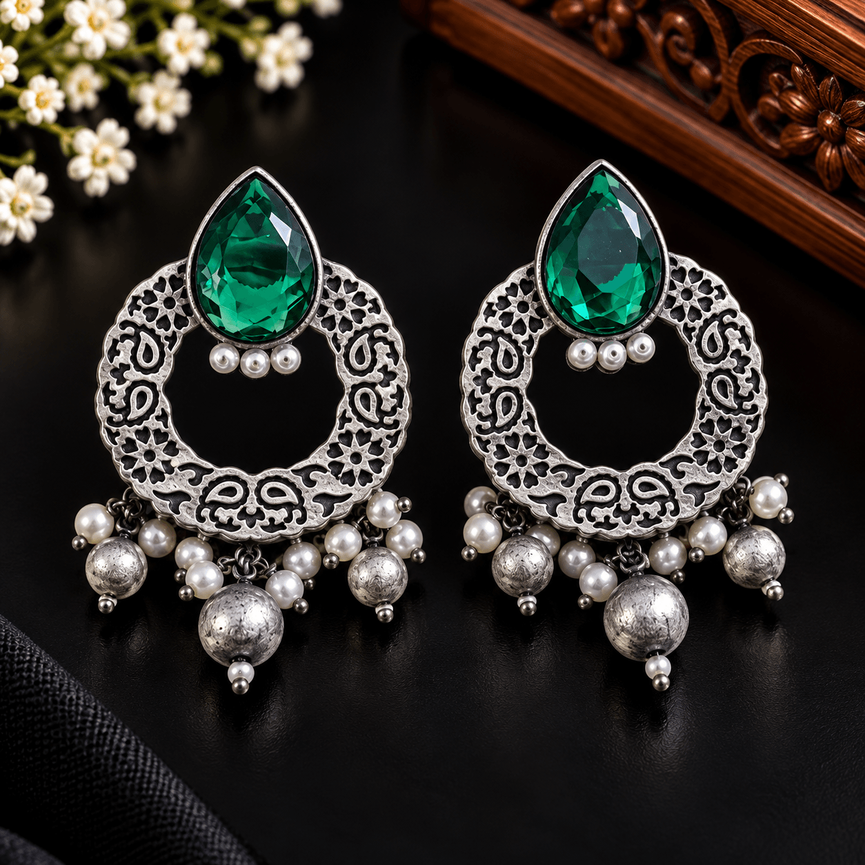 Emerald-green teardrop stone oxidized earrings with circular filigree frames and pearl-style dangling beads