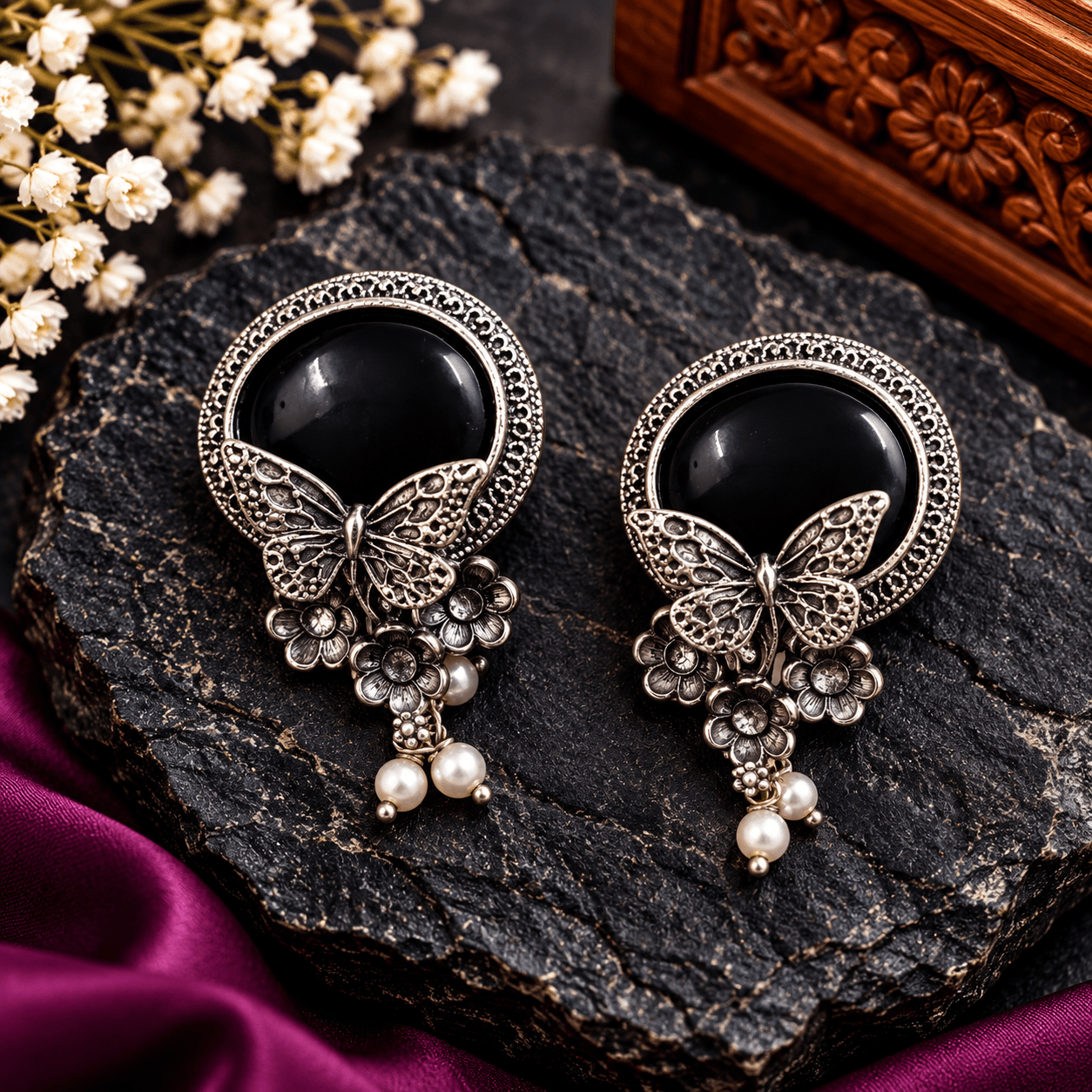 Black stone butterfly pendant necklace with oxidized silver-tone floral detailing, beaded chain, pearl-like drops, and matching earrings
