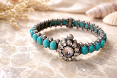 Turquoise beaded bracelet with silver accents on a textured surface