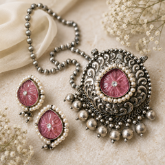 Oxidized silver pendant set with carved pink floral stone, pearl detailing, and matching earrings for ethnic and boho fashion by The Mirage Fashion.