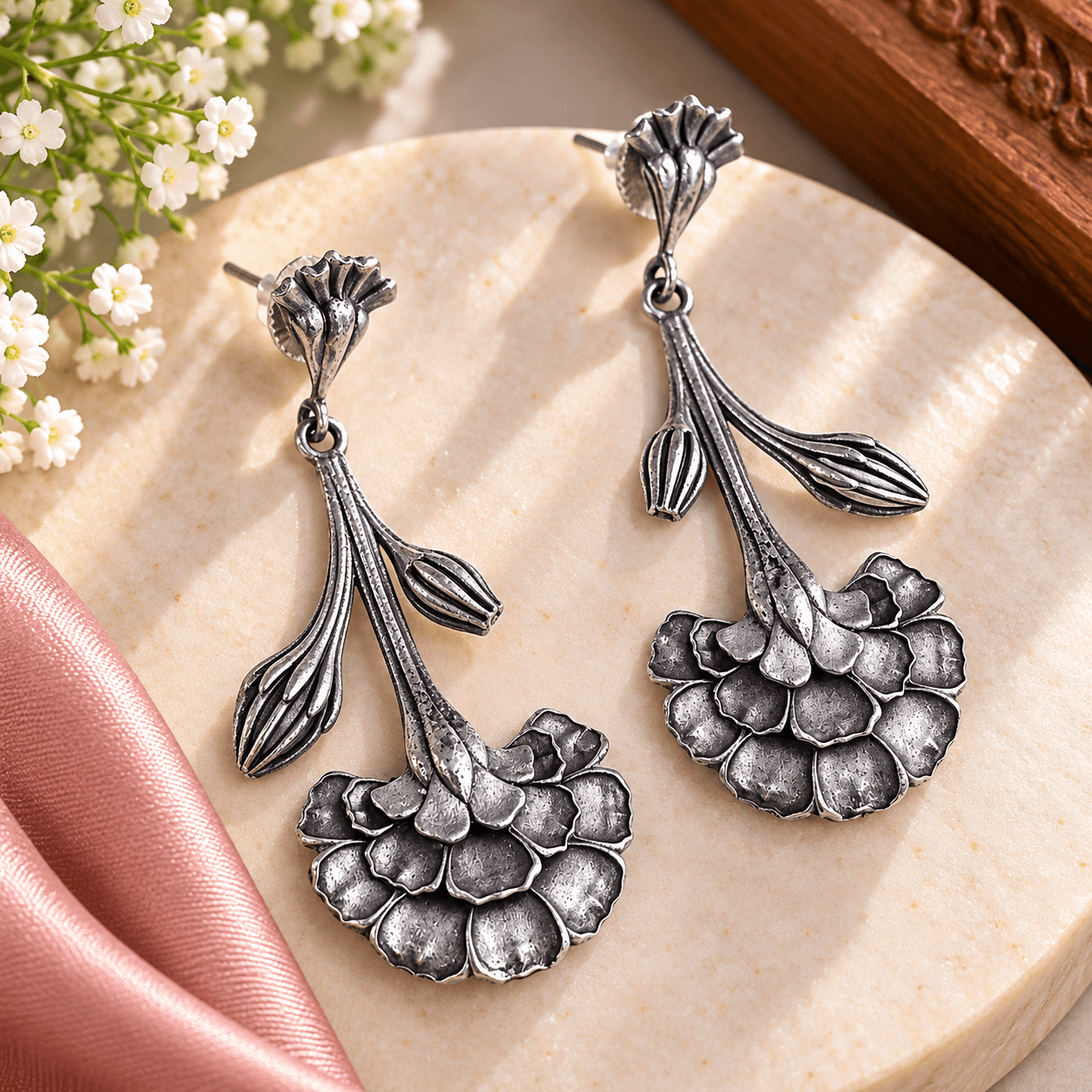 Antique silver-tone floral oxidized drop earrings with layered textured petals and sculpted botanical stems