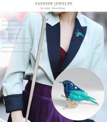 Person wearing a stylish outfit with a close-up of a blue bird-shaped brooch.
