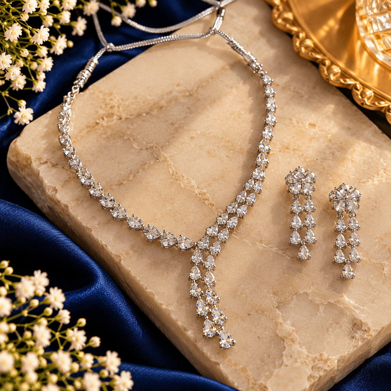 Silver-tone V-shaped crystal necklace with cascading teardrop details and matching long floral drop earrings