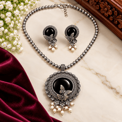 Black stone butterfly pendant necklace with oxidized silver-tone floral detailing, beaded chain, pearl-like drops, and matching earrings