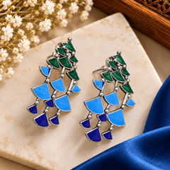 Blue and green geometric Meenakari-style cascade earrings with silver-tone borders and layered mosaic segments