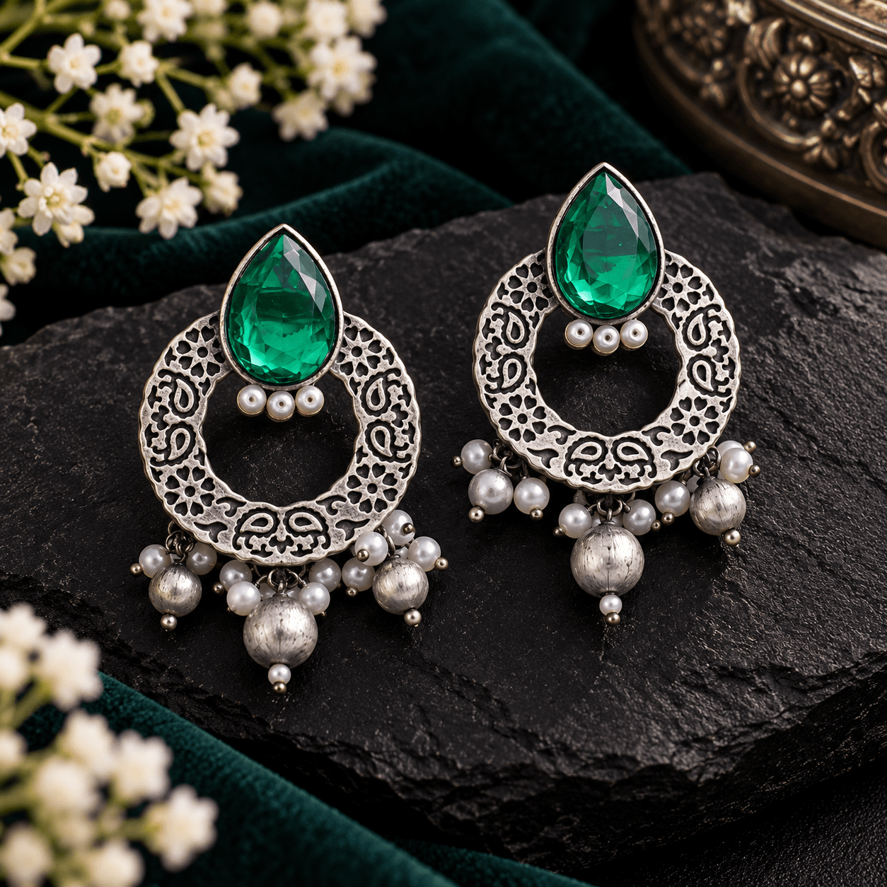 Emerald-green teardrop stone oxidized earrings with circular filigree frames and pearl-style dangling beads