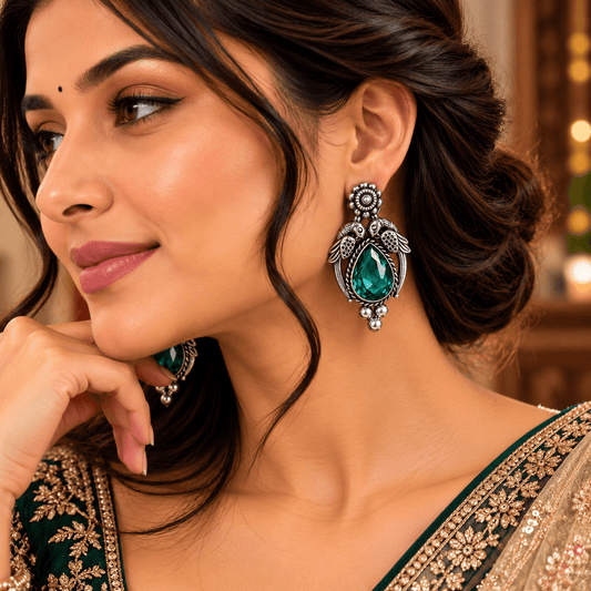 Emerald green teardrop oxidized statement earrings with decorative bird motifs by The Mirage Fashion