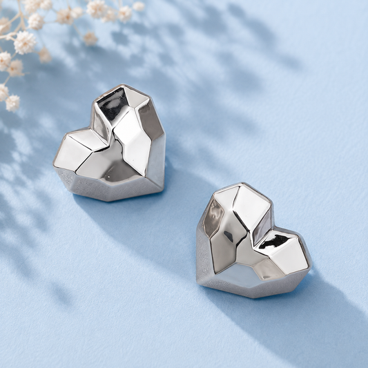 Geometric silver-tone heart stud earrings for women with faceted modern design