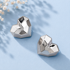Geometric silver-tone heart stud earrings for women with faceted modern design