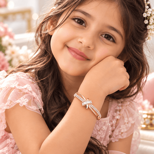 Young girl wearing the Little Princess Radiance rose-gold-tone bracelet by The Mirage Fashion