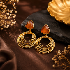Gold tone geometric drop earrings with orange coloured stone and concentric circles