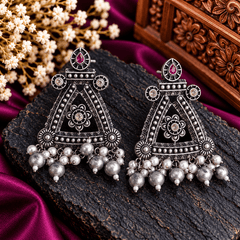 Oxidized silver-tone hanging earrings with pink stones, geometric detailing and white pearl-style drops