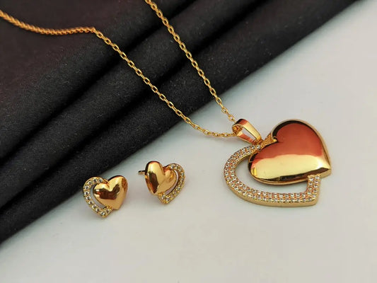 Gold heart-shaped jewelry set on a black and white background