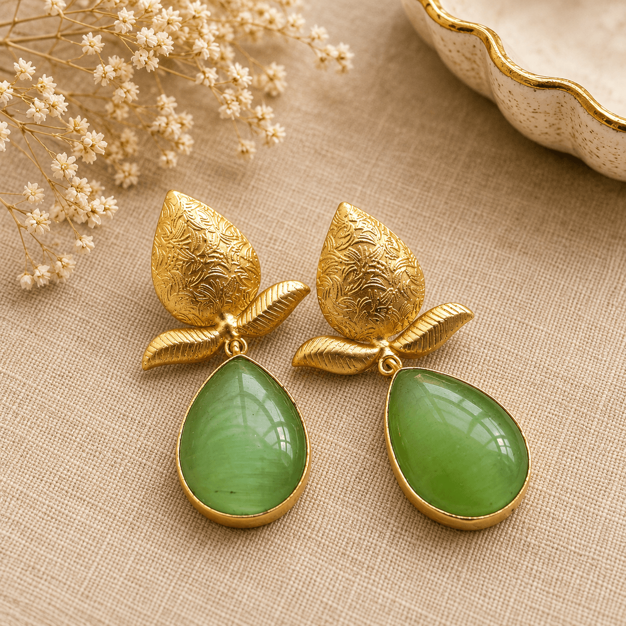 Green teardrop statement earrings with engraved gold-tone leaf designs by The Mirage Fashion